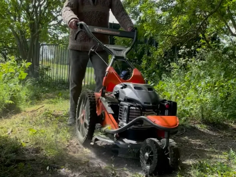 Vrijwilliger maait met de maaier het mountainbikeparcours op de Bult